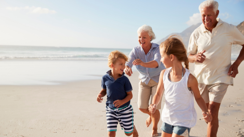 Grandparents on the beach with their children